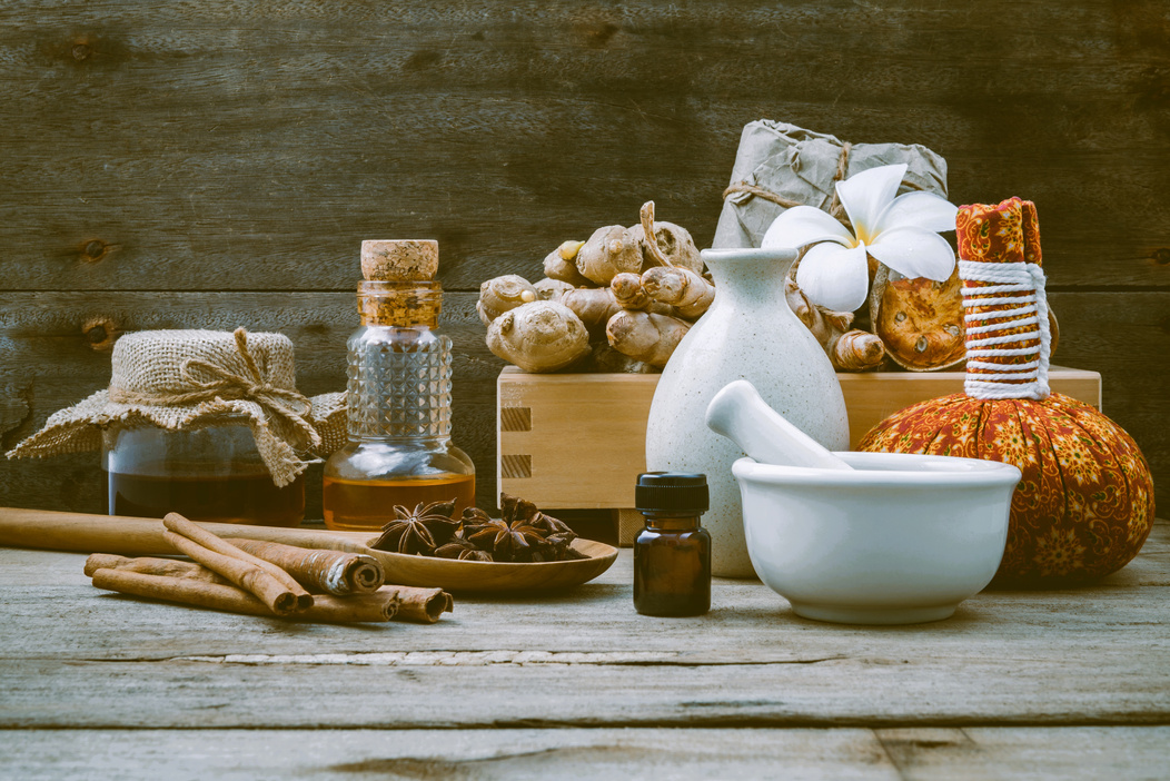 Natural Spa Ingredients and Herbal Compress Ball for Alternative Medicine and Relaxation. Thai Spa Theme with Ayurvedic Therapist on Shabby Wooden Background.